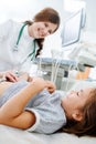 Chatty female doctor pressing her fingers against stomach of a little girl