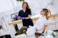 Young female doctor with protective gloves examining radiograph with her patient in the dentist office Royalty Free Stock Photo