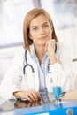 Young female doctor sitting at desk in office Royalty Free Stock Photo