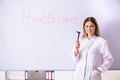 The young female doctor standing in front of the white board Royalty Free Stock Photo