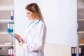 The young female doctor standing in front of the white board Royalty Free Stock Photo