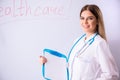 The young female doctor standing in front of the white board Royalty Free Stock Photo