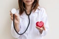 Young female doctor with the stethoscope holding red heart, cardiolog healthy care Royalty Free Stock Photo