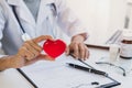 Young female doctor with the stethoscope holding red heart Royalty Free Stock Photo