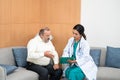 Young female doctor in white medical gown showing medical test result explaining prescription using clipboard senior man patient Royalty Free Stock Photo