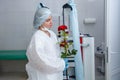 A young female doctor in a white protective suit, cap and gloves holds a red rose presented to her Royalty Free Stock Photo