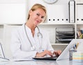 young female doctor working on computer in home office Royalty Free Stock Photo