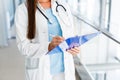 Young female doctor writes on paperboard Royalty Free Stock Photo