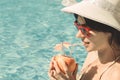 Young female drinking grapefruit juice next to the swimming pool Royalty Free Stock Photo