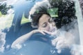 Young female driver at the wheel of her car, very tired, falling asleep while driving in a potentially dangerous situation . Royalty Free Stock Photo