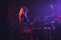 Young female drummer performing in illuminated nightclub Royalty Free Stock Photo