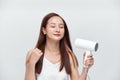 Young female drying her beautiful hair with hairdryer Royalty Free Stock Photo