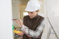 Young female electrician installing electrical socket on wall Royalty Free Stock Photo