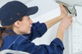 young female electrician installing electrical socket on wall with screwdriver Royalty Free Stock Photo