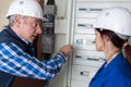 Young female electrician with mentor