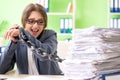 The young female employee busy with ongoing paperwork chained to the desk Royalty Free Stock Photo