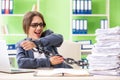 Young female employee busy with ongoing paperwork chained to th Royalty Free Stock Photo