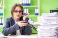 Young female employee busy with ongoing paperwork chained to th Royalty Free Stock Photo