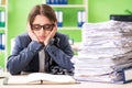 Young female employee busy with ongoing paperwork chained to th Royalty Free Stock Photo