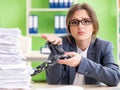 Young female employee busy with ongoing paperwork chained to th Royalty Free Stock Photo