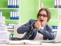 Young female employee busy with ongoing paperwork chained to th Royalty Free Stock Photo