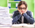 Young female employee busy with ongoing paperwork chained to th Royalty Free Stock Photo