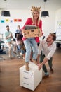 A young female employee is posing for a photo while having fun with her colleagues in the office. Employees, job, office Royalty Free Stock Photo