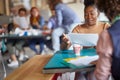 A young female employee is reading documents while working in the office Royalty Free Stock Photo