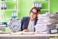 The young female employee very busy with ongoing paperwork in time management concept Royalty Free Stock Photo