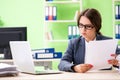 The young female employee very busy with ongoing paperwork