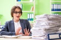 The young female employee very busy with ongoing paperwork