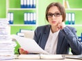 Young female employee very busy with ongoing paperwork Royalty Free Stock Photo