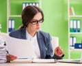 Young female employee very busy with ongoing paperwork Royalty Free Stock Photo
