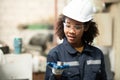 A young female engineer inspects and repairs parts of a robotic welding machine Royalty Free Stock Photo