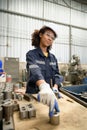 A young female engineer inspects and repairs parts of a robotic welding machine Royalty Free Stock Photo