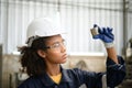 A young female engineer inspects and repairs parts of a robotic welding machine Royalty Free Stock Photo