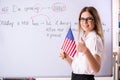 The young female english language teacher standing in front of the blackboard Royalty Free Stock Photo