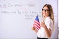 The young female english language teacher standing in front of the blackboard Royalty Free Stock Photo