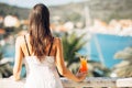 Young female enjoying a colourful cocktail on the panoramic view hotel terrace.Cold delicious cocktail smoothie