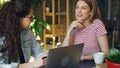 Young female enterpreneurs sitting together at table and talking emotionally. Women are wearing casual clothes and