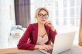 Young female entrepreneur sitting at table in her home office working on laptop Royalty Free Stock Photo
