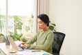 Young female entrepreneur working sitting at a desk typing on her laptop in a home office Royalty Free Stock Photo