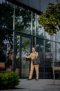 Young female executive standing outside office building talking on cell phone. Caucacian businesswoman making a phone call while Royalty Free Stock Photo