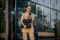 Young female executive standing outside office building talking on cell phone. Caucacian businesswoman making a phone call while Royalty Free Stock Photo