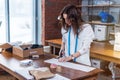 Young female fashion designer cutting fabric with scissors in studio Royalty Free Stock Photo