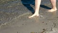 Young female feet walking in the shallow water at a baltic sea beach in summer Royalty Free Stock Photo