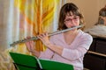 A young female flautist plays a wind instrument flute and looking at the notes Royalty Free Stock Photo
