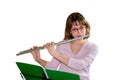 A young female flautist plays a wind instrument flute and looking at the