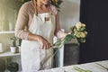 Female florist working in her flower shop trimming a bouquet Royalty Free Stock Photo