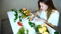 Young female flower handler keeps record of flowers and writes o